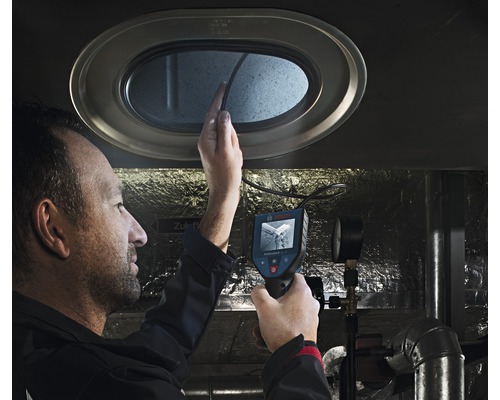 Muž používa inšpekčnú kameru na kontrolu otvoru.