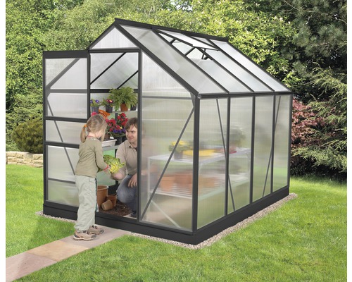 Skleník s osobou a dieťaťom, ktoré sadia rastliny