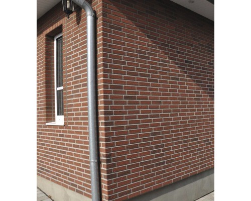 Exteriér domu s tehlovou fasádou a odkvapom