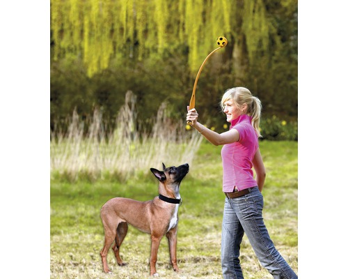 Žena hádže loptu s odpaľovačom lôpt pre psa