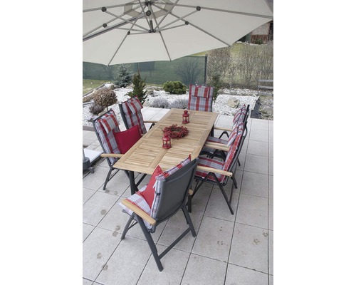 Záhradná sedacia súprava s jedálenským stolom, stoličkami a slnečníkom na terase.