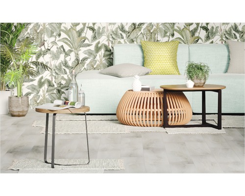 Obývacia izba s pohovkou, konferenčnými stolíkmi a rastlinami pred vzorovanou tapetou