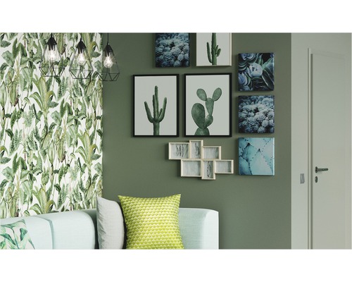 Obývacia izba s tropickou tapetou, obrázkami kaktusov a geometrickými lampami