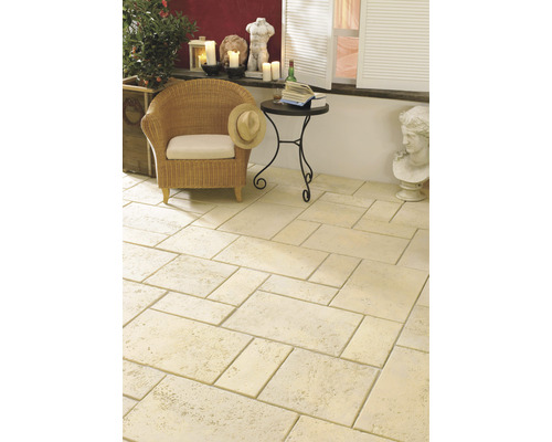 Terasa s kamennými dlaždicami, prúteným kreslom a odkladacím stolíkom