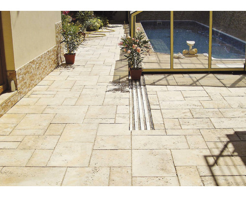 Exteriér s béžovými dlaždicami z prírodného kameňa a odvodňovacím žľabom