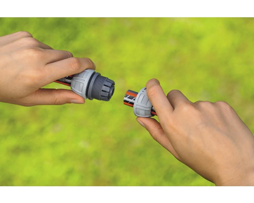 Dve ruky spájajú hadicovú spojku so záhradnou hadicou.