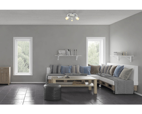 Obývacia izba s pohovkou z europaliet, konferenčným stolíkom a stropným svietidlom s tromi bodovými svetlami