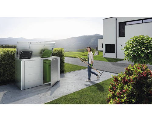 Kôš na odpadkové nádoby v záhrade so ženou so záhradným náradím