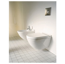 Závesná toaleta a bidet v kúpeľni s bielymi dlaždicami
