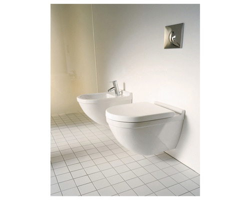 Závesná toaleta a bidet v kúpeľni s bielymi dlaždicami