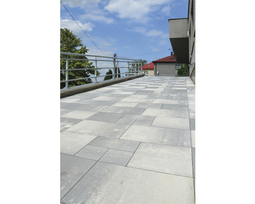 Terasa s betónovou dlažbou a zábradlím.