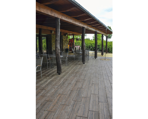 Terasa s drevenou podlahou a zastrešením s kmeňmi stromov ako podperami