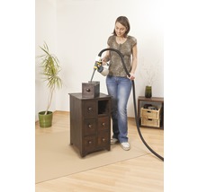 Žena lakuje nočný stolík pomocou systému na striekanie farby