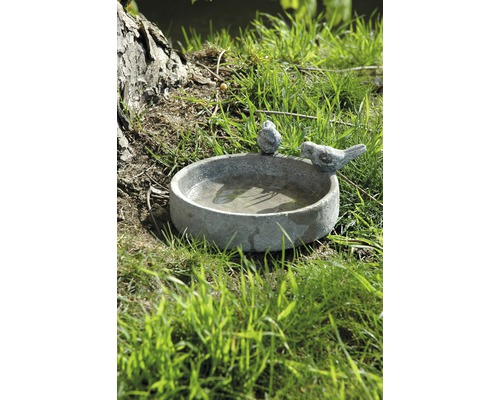 Kamenné napájadlo pre vtáky s dvoma vtáčími figúrkami v záhrade