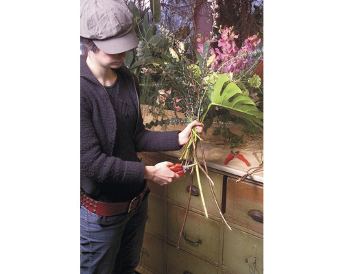 Žena strihá kvety záhradnými nožnicami na kvetinové aranžmány