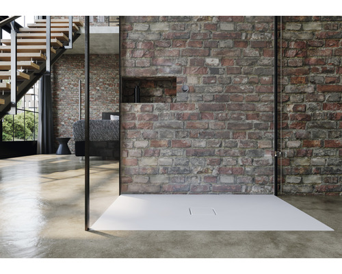 Kúpeľňa s rovnou sprchou, sklenenou stenou a tehlovou stenou.