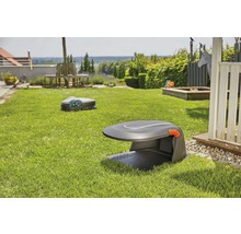 Dva robotické kosačky na trávu v záhrade s trávnikom a záhradným nábytkom.