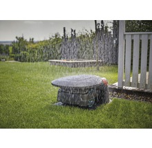 Robotická kosačka na trávu v prevádzke v daždi na trávniku.