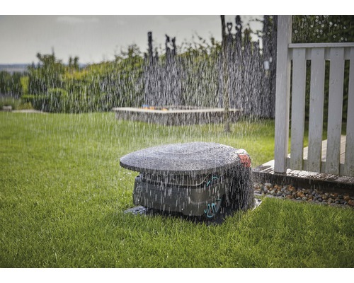 Robotická kosačka na trávu v prevádzke v daždi na trávniku.