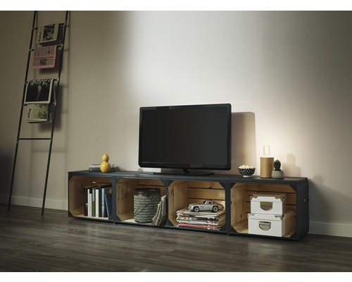 Obývacia izba s televíznou skrinkou z drevených debien, televízorom a stojanom na noviny