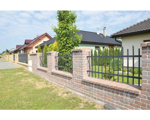 Plot z tehál a kovu pred obytnými domami