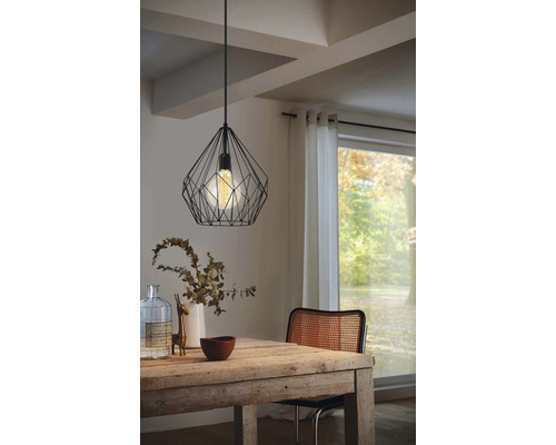 Jedáleň s dreveným stolom a čiernou závesnou lampou s drôteným dizajnom