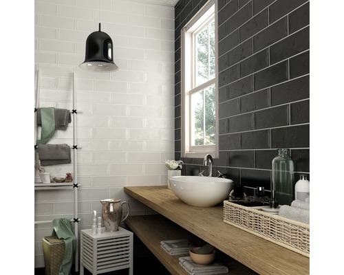 Kúpeľňa s bielymi a čiernymi obdĺžnikovými obkladačkami, umývadlom a drevenou policou