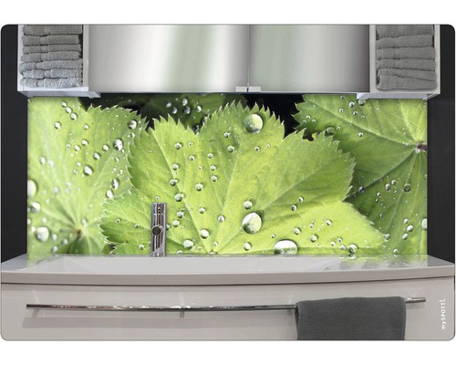 Kúpeľňa s umývadlom, uterákmi a nástenným panelom s listami a kvapkami vody