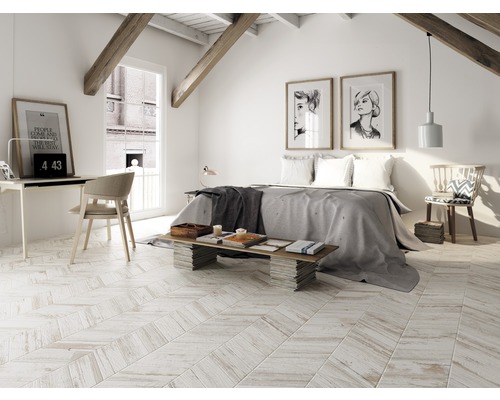 Svetlá spálňa v podkroví s posteľou, písacím stolom a drevenými trámami