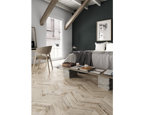 Svetlá spálňa so šikmou strechou, drevenými trámami a parketami v tvare rybej kosti