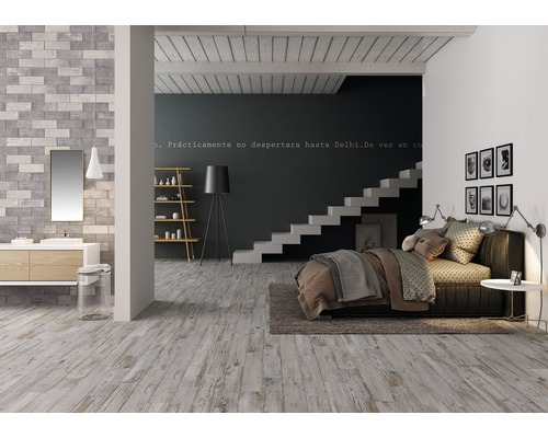 Svetlá izba s drevenou podlahou, posteľou, schodiskom a umývadlom