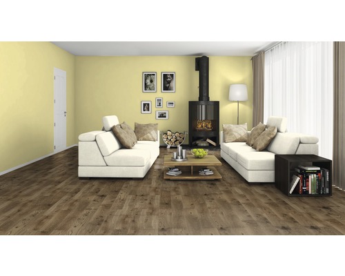 Obývacia izba so svetlou pohovkou, krbom a drevenou podlahou