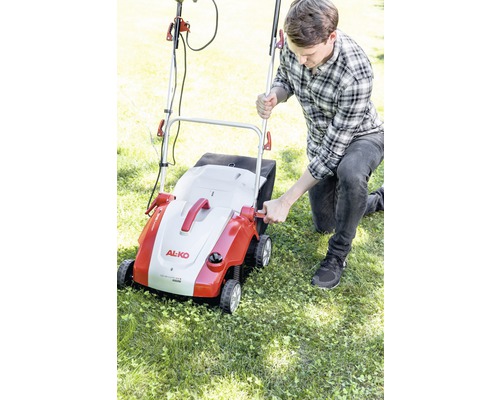 Muž obsluhuje prevzdušňovač trávnika značky AL-KO v záhrade.