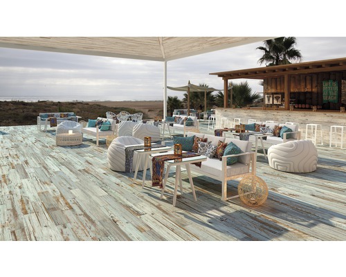 Vonkajšie posedenie s drevenou podlahou, nábytkom a výhľadom na more