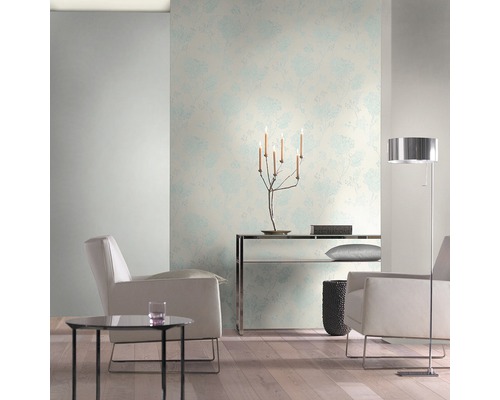 Svetlá obývacia izba s kvetinovou tapetou, kreslami a stojacou lampou.