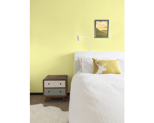 Spálňa s posteľou, nočným stolíkom a nástennou dekoráciou pre útulnú atmosféru.