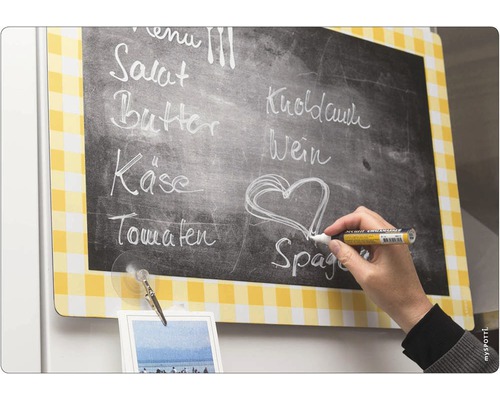 Magnetická tabuľa so žltým kockovaným vzorom a kriedový popisovač v ruke