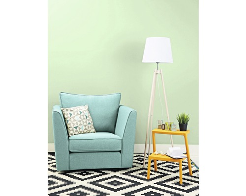 Obývacia izba s kreslom, vankúšom, stojacou lampou a kobercom s geometrickým vzorom