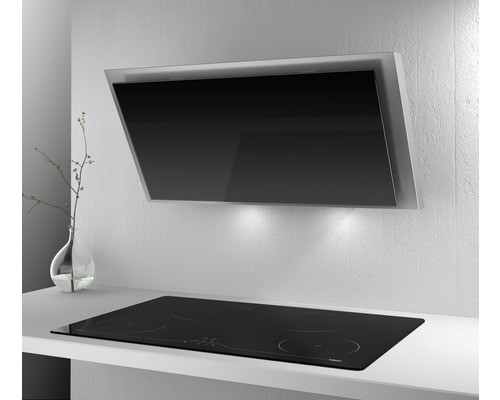 Nástenný digestor nad varnou doskou vo svetlej kuchyni.