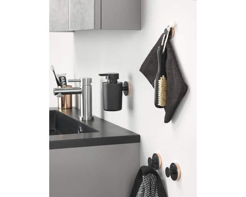 Kúpeľňový umývadlový priestor s vodovodnou batériou, dávkovačom mydla, uterákmi a háčikmi.