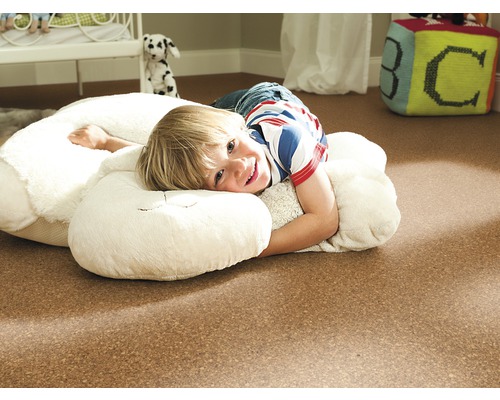 Chlapec leží na korkovej podlahe v detskej izbe