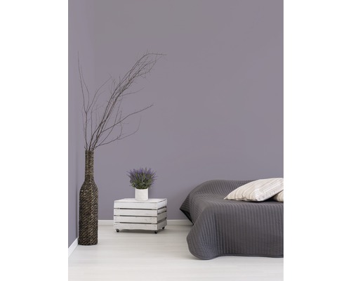 Spálňa s posteľou, drevená debna na kolieskach ako nočný stolík, váza a dekorácia