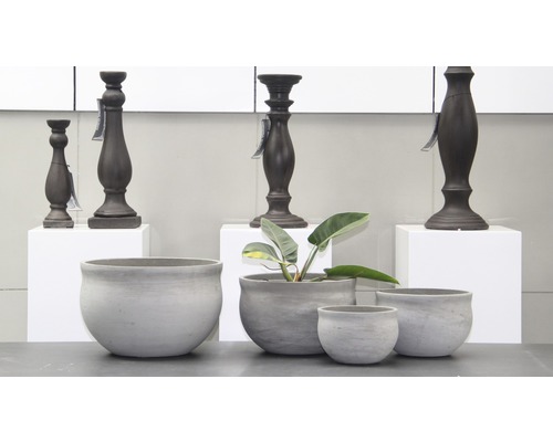 Dekoratívne sivé kvetináče a tmavé svietniky na stole