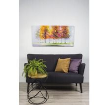 Scéna s pohovkou, vankúšmi, príručným stolíkom s rastlinou a nástennou maľbou.