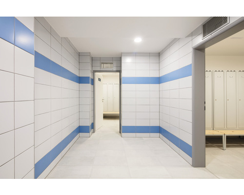 Chodba s obloženými stenami a šatňou v pozadí