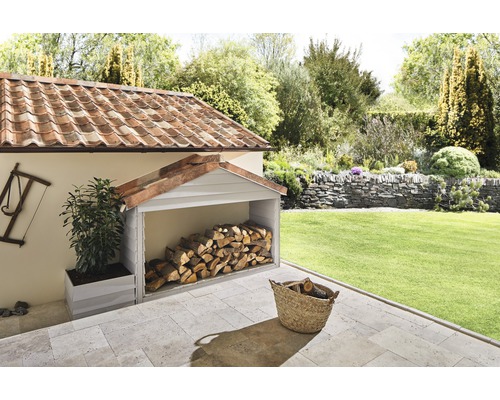 Zastrešené miesto na ukladanie dreva v záhrade s krbovým drevom a kvetináčom