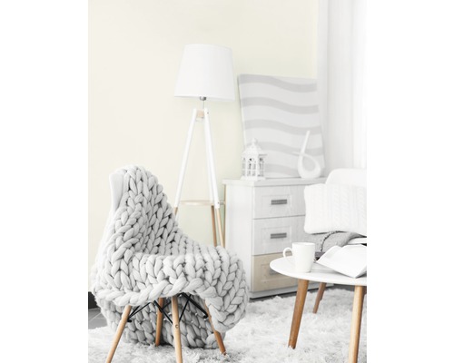 Obývacia izba so stoličkou, pletenou dekou, stojacou lampou, príručným stolíkom a komodou