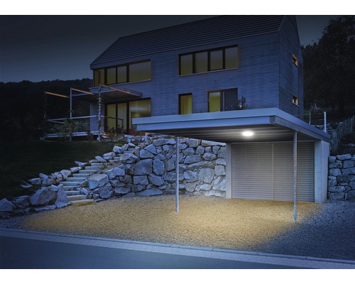Osvetlený prístrešok pre auto pri modernom dome s kamenným schodiskom