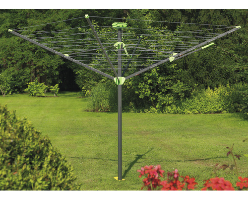 Rotačný sušiak na bielizeň v záhrade so zeleným trávnikom v pozadí.