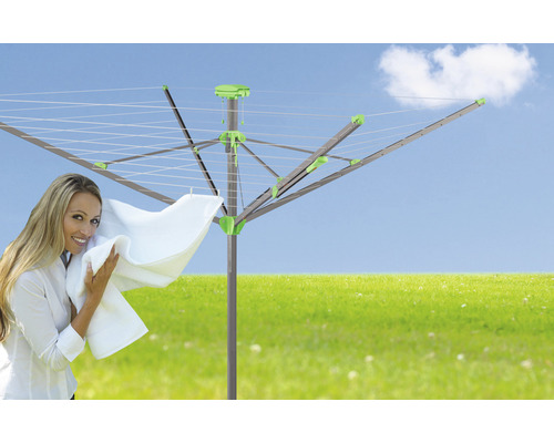 Rotačný sušiak na bielizeň v záhrade so ženou a bielizňou